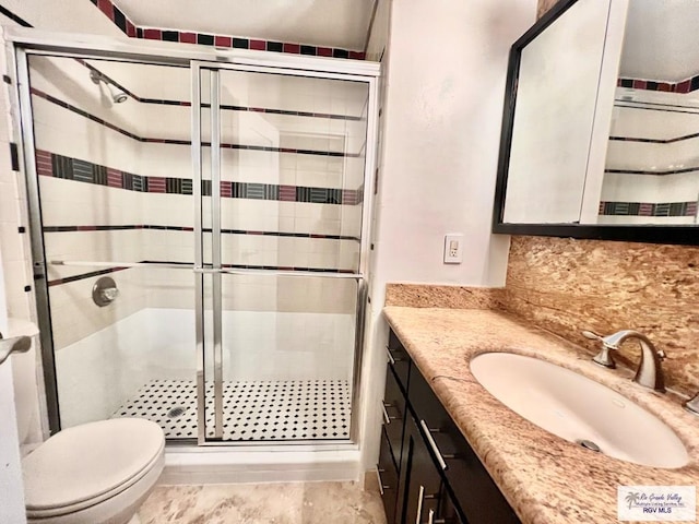 2901 Central Blvd Unit 306, Brownsville, TX 78520 - bathroom with a stall shower, backsplash, vanity, and toilet