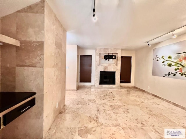 2901 Central Blvd Unit 306, Brownsville, TX 78520 - unfurnished living room with rail lighting, a large fireplace, and baseboards