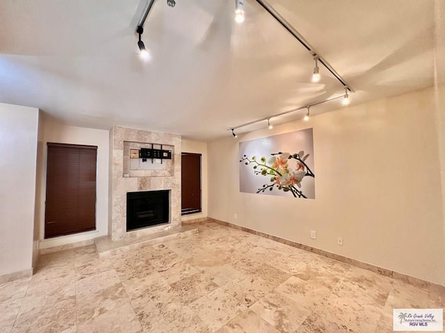 2901 Central Blvd Unit 306, Brownsville, TX 78520 - unfurnished living room featuring rail lighting, a fireplace, and baseboards