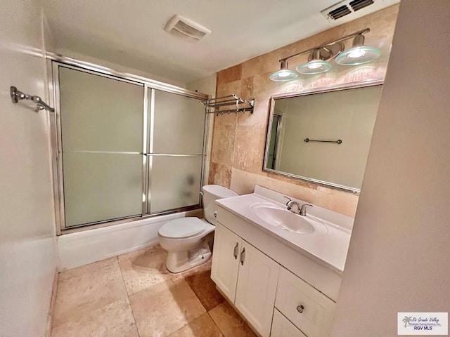 2901 Central Blvd Unit 306, Brownsville, TX 78520 - full bath with tile walls, toilet, vanity, tasteful backsplash, and enclosed tub / shower combo