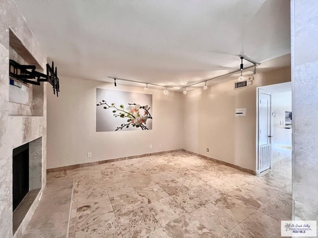 2901 Central Blvd Unit 306, Brownsville, TX 78520 - unfurnished living room featuring baseboards, a fireplace, and track lighting