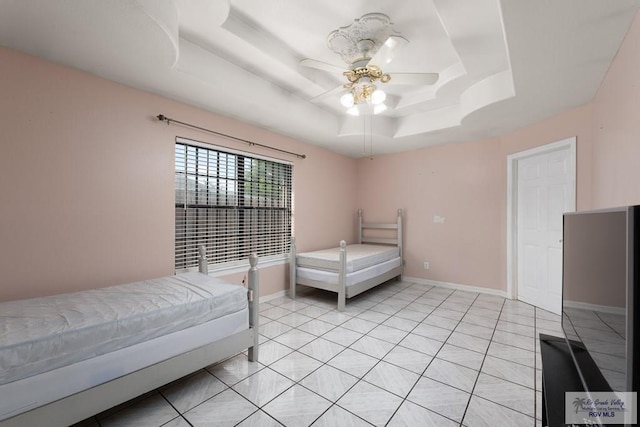 bedroom with light tile patterned floors, a raised ceiling, and ceiling fan