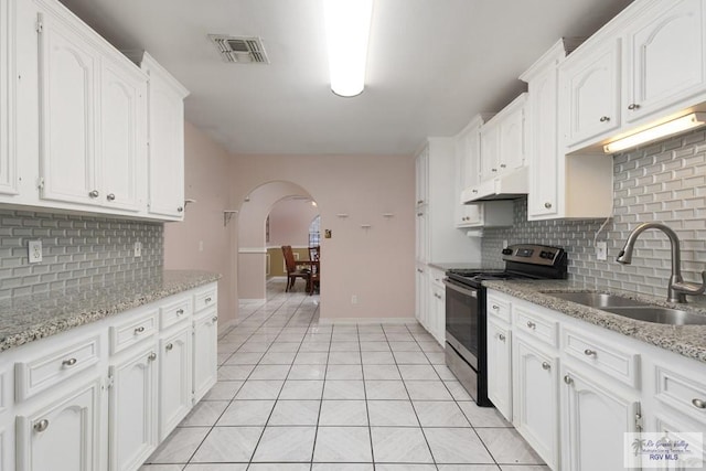 kitchen featuring decorative backsplash, white cabinetry, black range with electric stovetop, and sink