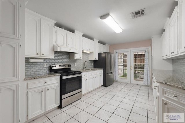 kitchen with appliances with stainless steel finishes, backsplash, sink, white cabinetry, and light tile patterned flooring