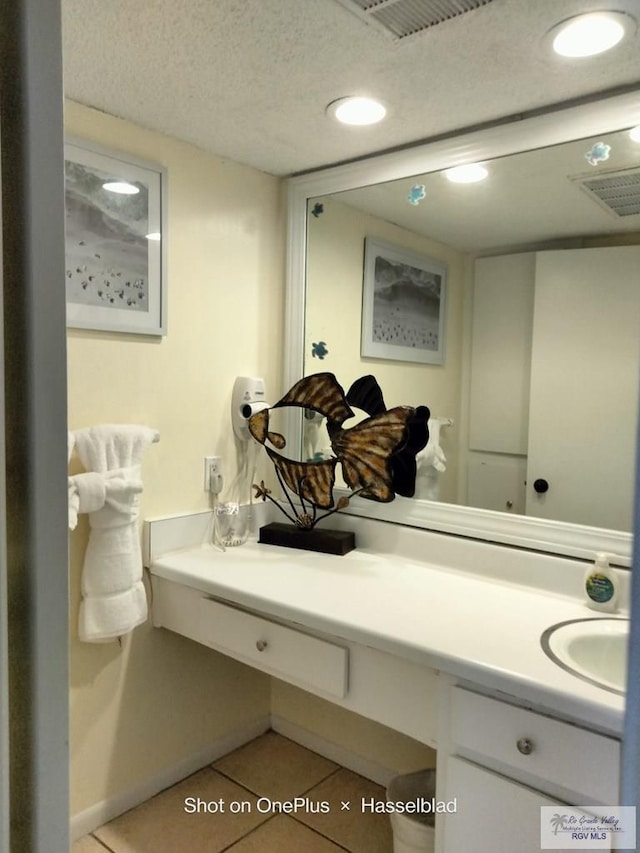 bathroom with tile patterned floors, visible vents, a textured ceiling, and vanity