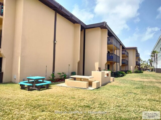 6608 Padre Blvd Unit D-253, South Padre Island, TX 78597 - rear view of property with stucco siding and a yard