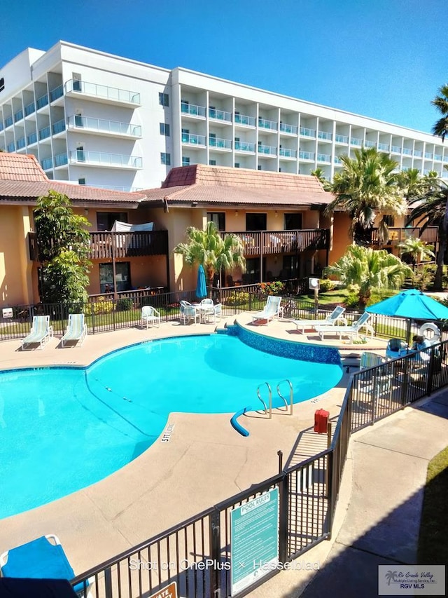 community pool featuring a patio and fence