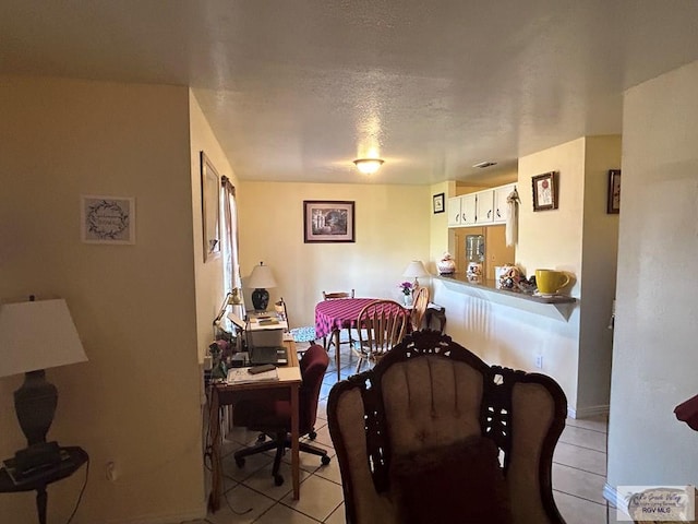 tiled dining room with a textured ceiling