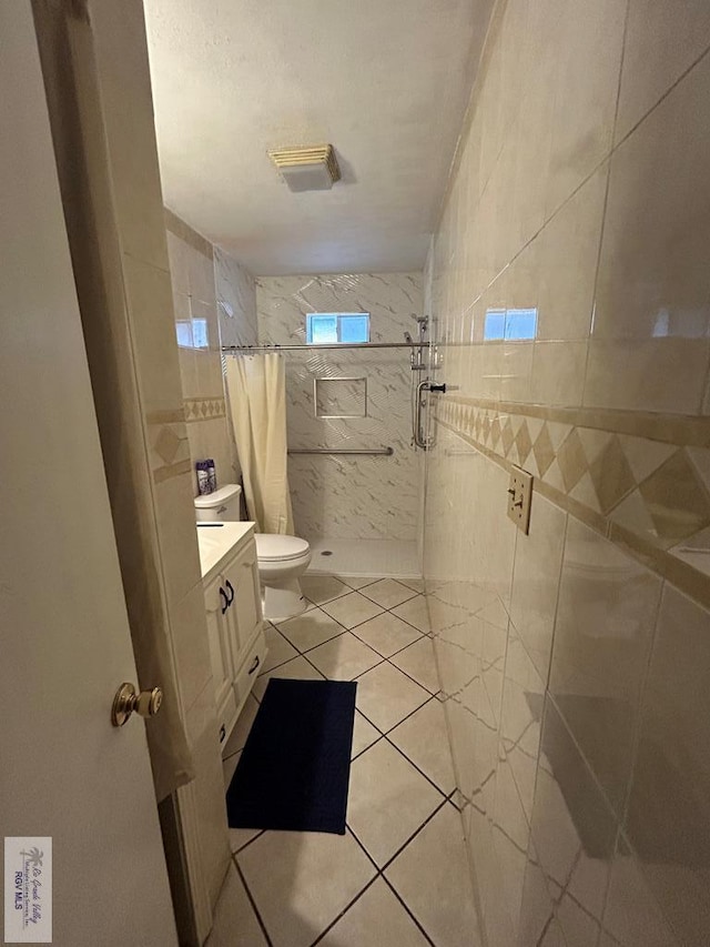 bathroom featuring a shower with curtain, tile patterned flooring, vanity, and tile walls