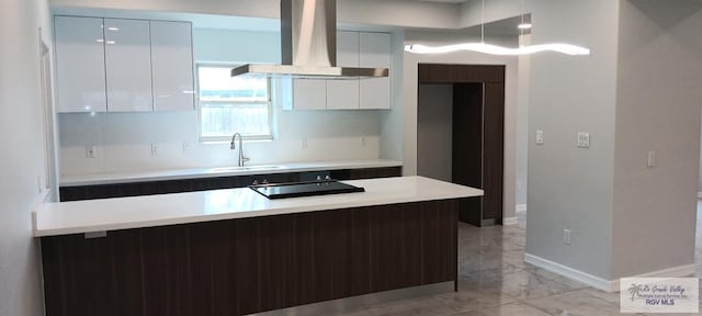 kitchen with black electric stovetop, white cabinetry, wall chimney exhaust hood, and sink