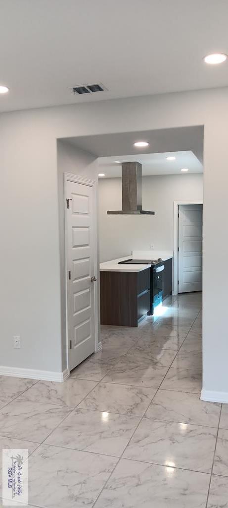 kitchen featuring wall chimney range hood