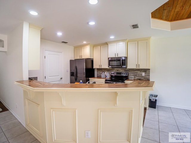 17077 Tangelo Ave, Harlingen, TX 78552 - kitchen with appliances with stainless steel finishes, light tile patterned flooring, decorative backsplash, a peninsula, and recessed lighting