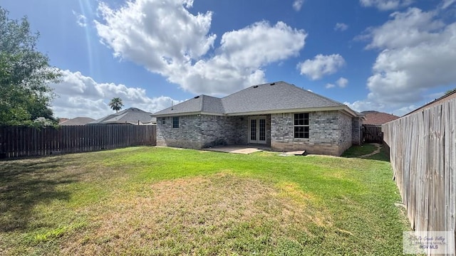 17077 Tangelo Ave, Harlingen, TX 78552 - rear view of house with french doors, brick siding, a fenced backyard, and a patio