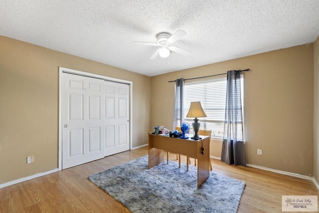 home office featuring a textured ceiling, light hardwood / wood-style floors, and ceiling fan