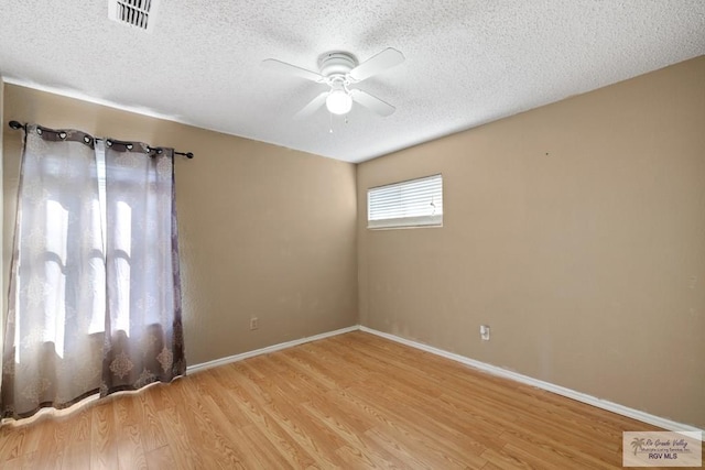 unfurnished room featuring ceiling fan, light wood-type flooring, and a textured ceiling