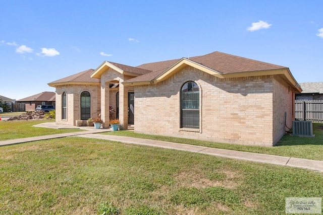 view of front of home with a front lawn, central air condition unit, fence, and brick siding