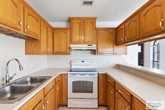 kitchen with visible vents, under cabinet range hood, a sink, white range with electric stovetop, and brown cabinetry