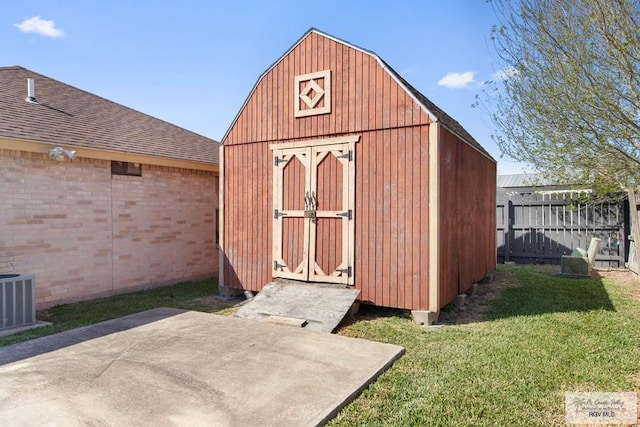 view of shed with central air condition unit and fence