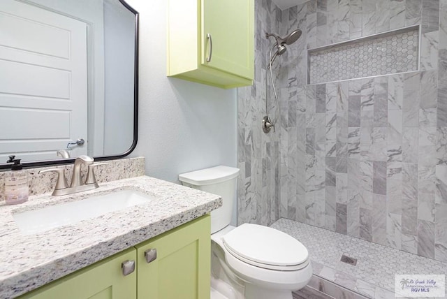 bathroom featuring tiled shower, vanity, and toilet