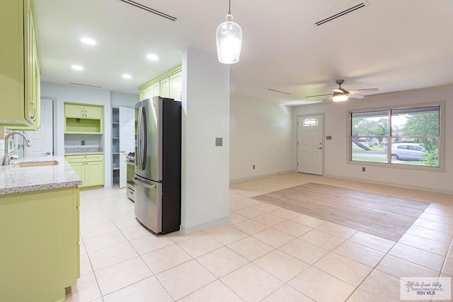 kitchen featuring light stone countertops, stainless steel appliances, ceiling fan, sink, and decorative light fixtures