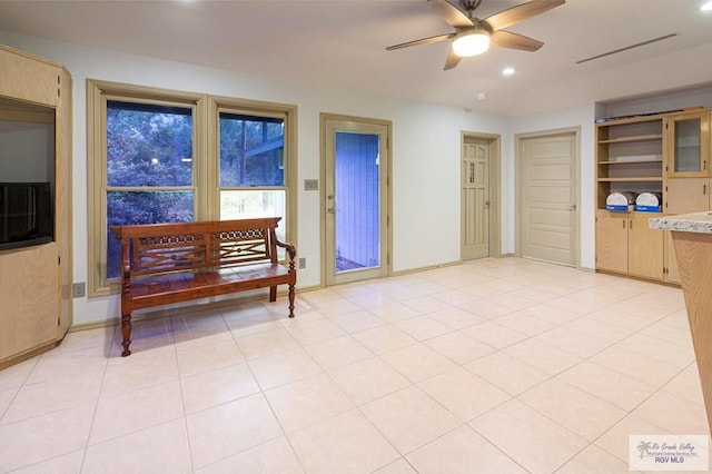 interior space featuring ceiling fan and built in shelves