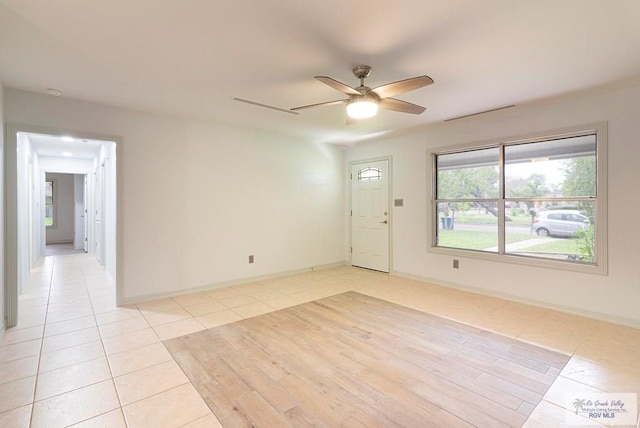 tiled empty room featuring ceiling fan