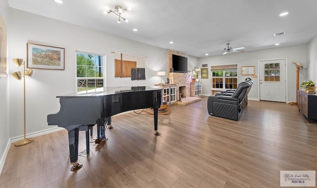 living room featuring wood finished floors, visible vents, a wealth of natural light, and ceiling fan