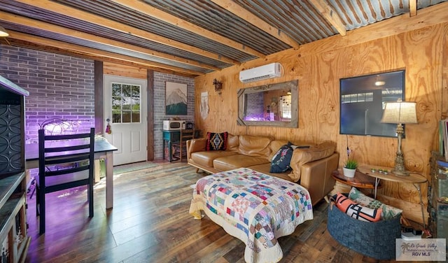 living room with beam ceiling, an AC wall unit, hardwood / wood-style floors, and wood walls