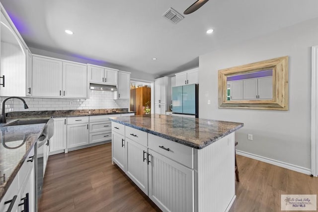 kitchen with visible vents, white cabinets, under cabinet range hood, appliances with stainless steel finishes, and backsplash