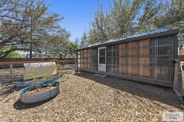 exterior space featuring an outbuilding, fence, and metal roof