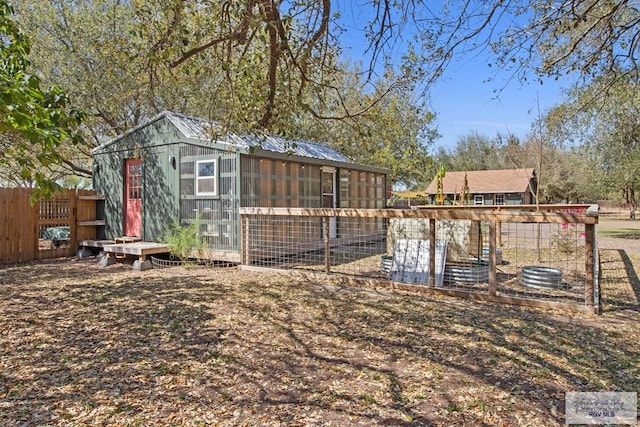 view of yard featuring exterior structure, an outdoor structure, and fence