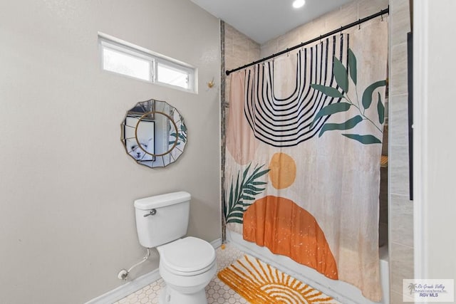 full bathroom with a shower with shower curtain, toilet, baseboards, and tile patterned floors