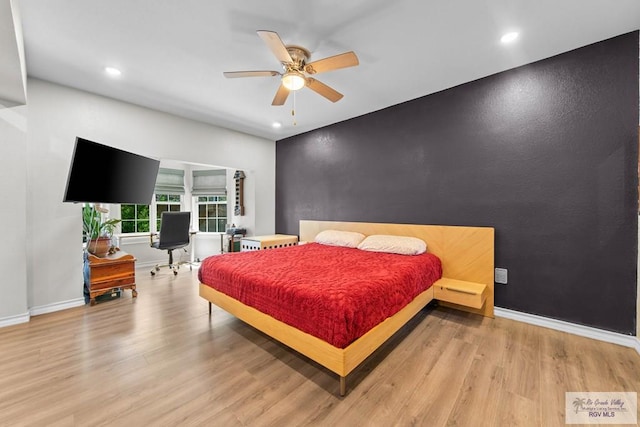 bedroom featuring a ceiling fan, baseboards, light wood finished floors, recessed lighting, and an accent wall