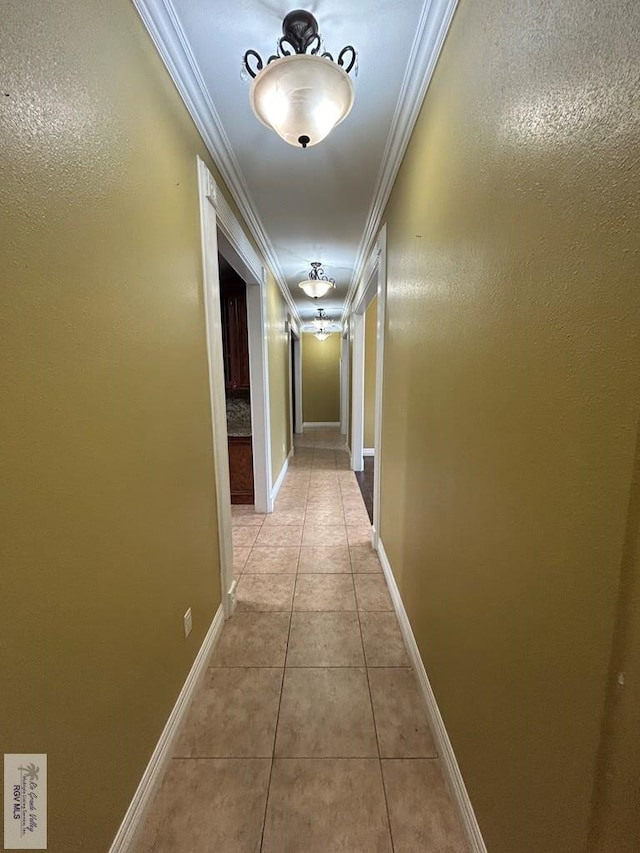 hallway featuring crown molding and light tile patterned floors