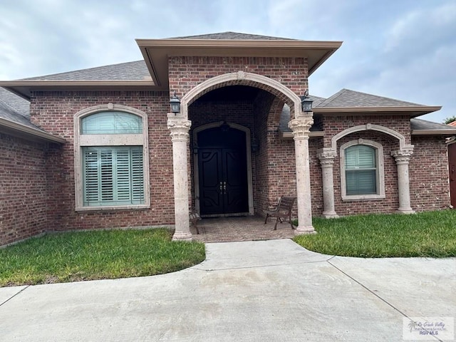 view of exterior entry with a yard