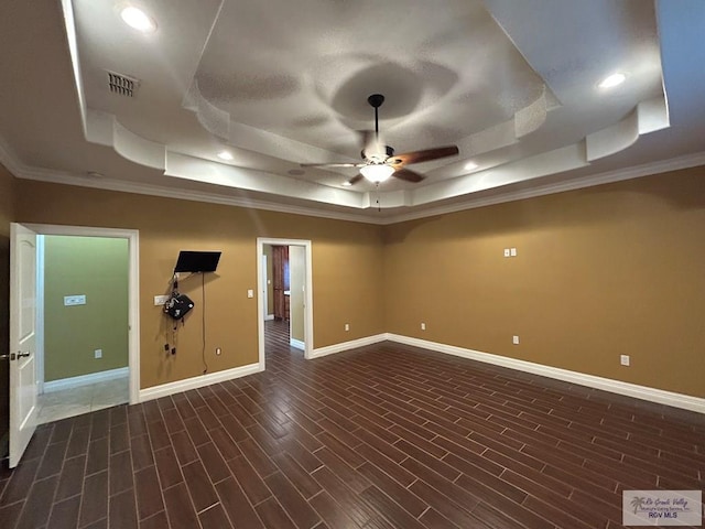 empty room featuring a raised ceiling, crown molding, and ceiling fan