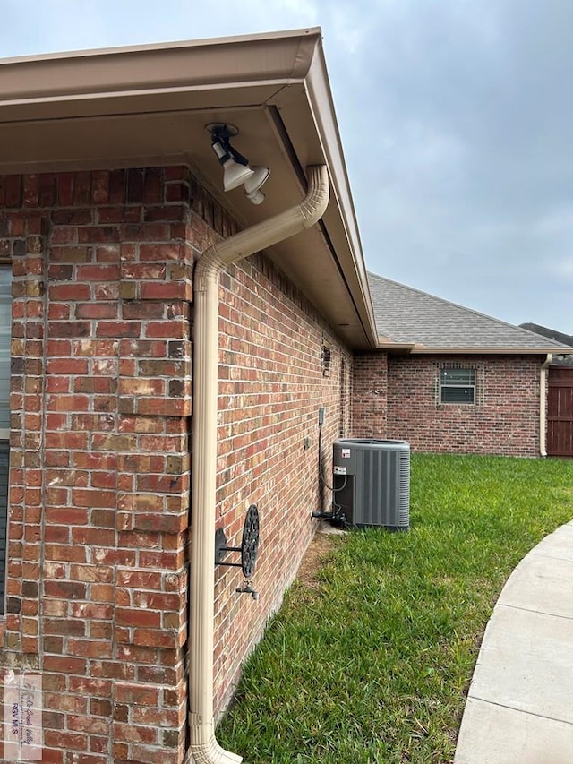 view of property exterior with central AC unit and a yard