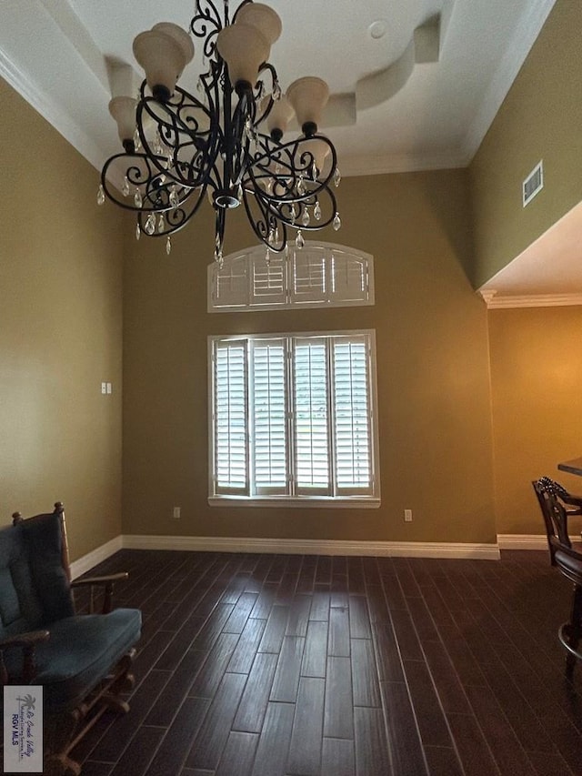 interior space featuring ornamental molding, dark hardwood / wood-style flooring, and a chandelier