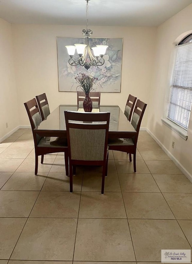 tiled dining space with a notable chandelier