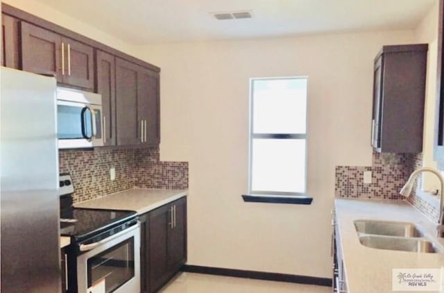 kitchen featuring tasteful backsplash, sink, stainless steel appliances, and dark brown cabinets