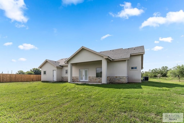 rear view of house with french doors, a yard, and cooling unit