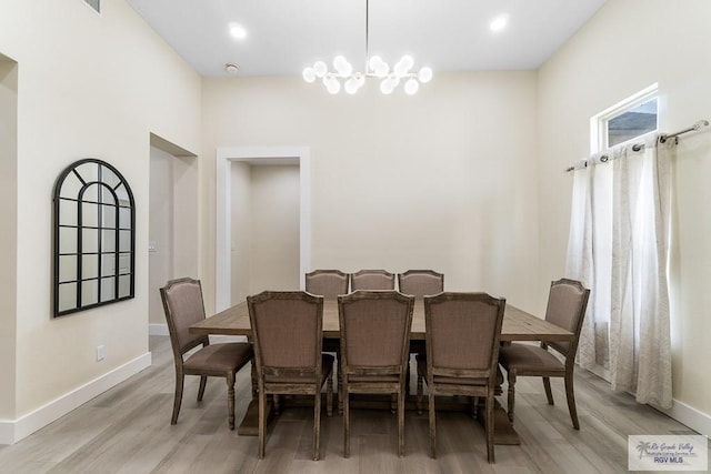 dining area with a chandelier and light wood-type flooring