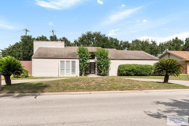 716 E Palm Valley Dr, Harlingen, TX 78550 - view of front of property with a chimney, a front yard, and brick siding