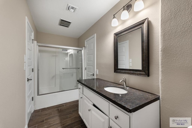 716 E Palm Valley Dr, Harlingen, TX 78550 - full bathroom with vanity, wood finished floors, and shower / bath combination with glass door