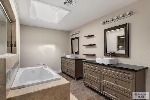 716 E Palm Valley Dr, Harlingen, TX 78550 - full bath featuring two vanities, a garden tub, and wood finished floors