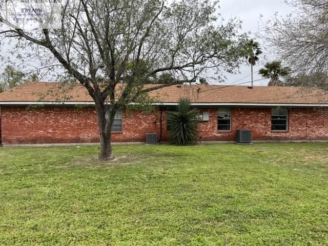 rear view of house with a yard and central AC