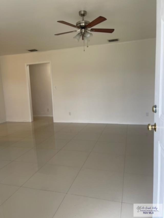 empty room featuring ceiling fan and tile patterned flooring