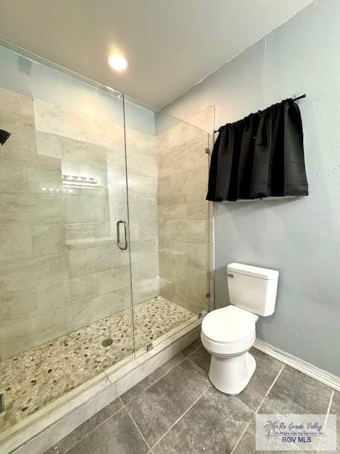 bathroom with tile patterned floors, toilet, and an enclosed shower