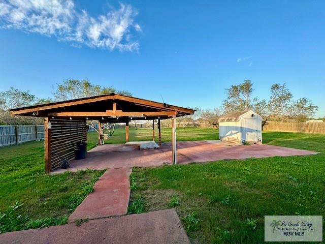 surrounding community with a storage shed, a patio, and a lawn