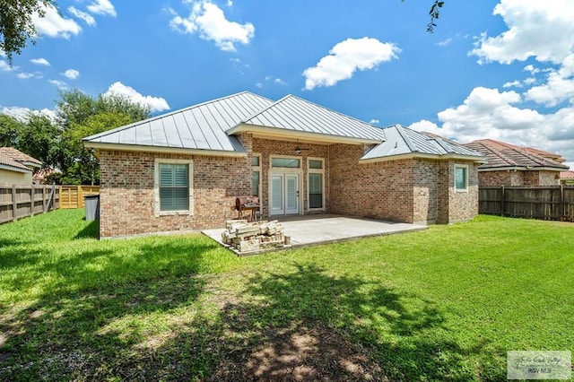 back of house featuring a patio, french doors, and a lawn